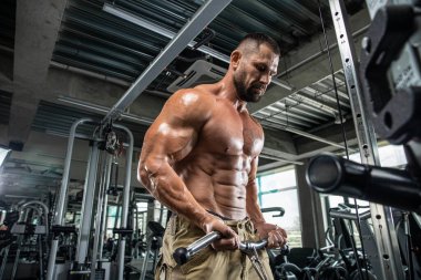 Çekici uzun kaslı vücut geliştirici. Moder fitness merkezinde ağırlık kaldırıyor..