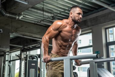 Çekici uzun kaslı vücut geliştirici. Moder fitness merkezinde ağırlık kaldırıyor..