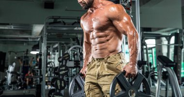 Çekici uzun kaslı vücut geliştirici. Moder fitness merkezinde ağırlık kaldırıyor..