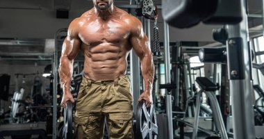 Çekici uzun kaslı vücut geliştirici. Moder fitness merkezinde ağırlık kaldırıyor..