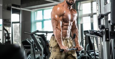 Çekici uzun kaslı vücut geliştirici. Moder fitness merkezinde ağırlık kaldırıyor..