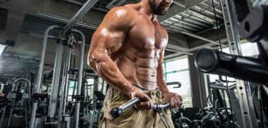 Çekici uzun kaslı vücut geliştirici. Moder fitness merkezinde ağırlık kaldırıyor..