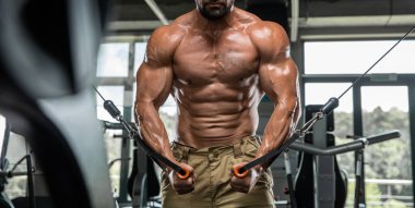 Çekici uzun kaslı vücut geliştirici. Moder fitness merkezinde ağırlık kaldırıyor..