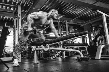 Çekici uzun kaslı vücut geliştirici. Moder fitness merkezinde ağırlık kaldırıyor..