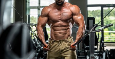 Çekici uzun kaslı vücut geliştirici. Moder fitness merkezinde ağırlık kaldırıyor..