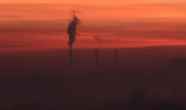 Napnyugtakor ég füst gyárban — Stock Fotó