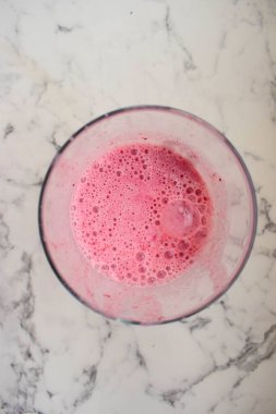 Ahududu kokteyli. Üst manzara. Bardak masanın üstünde.