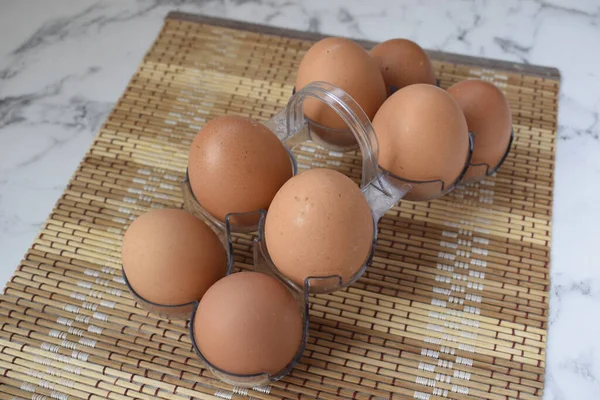 Chicken eggs, a lot in a stand on the table. Egg on a brown background