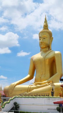 Mavi ve bulutlu gökyüzünde oturan büyük Buda görüntüsü
