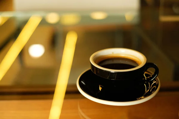 Caffè Caldo Tazza Nera Sfondo Chiaro Sfocatura Gialla — Foto Stock