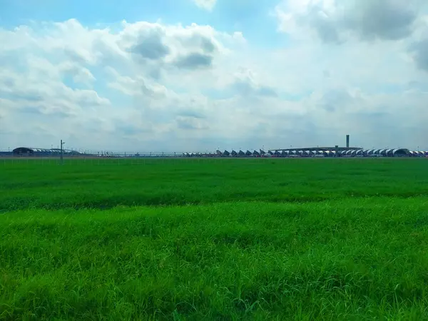 乌云密布的蓝天下 苏沃纳巴机场通过绿地的远程图像 — 图库照片