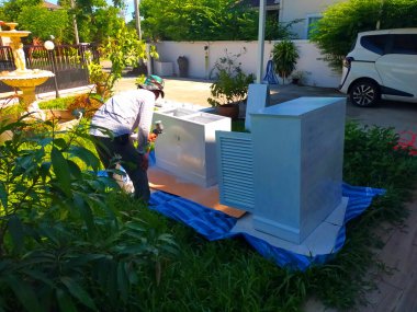 Bir adam bir evdeki masanın yüzeyine beyaz renk boyuyor.