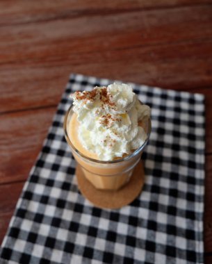 Ahşap masa cam bardakta süt smoothies ile buzlu çay.