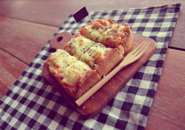 Pizza toasted bread with tomato sauce and ham cheese selective focus, picture vintage style