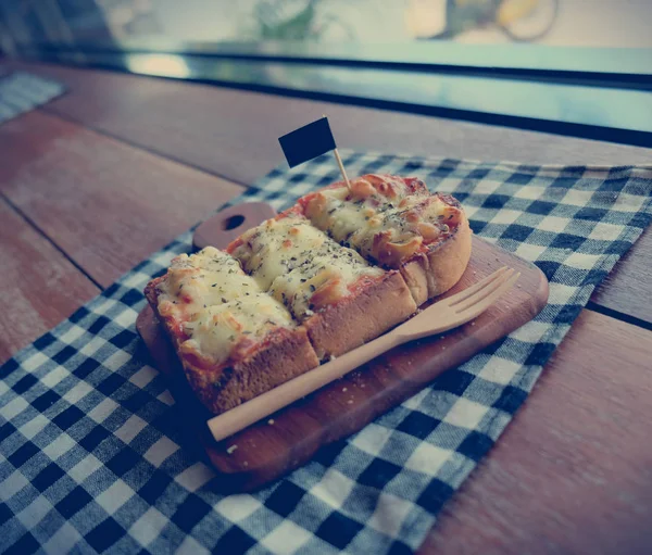 Pizza toasted bread with tomato sauce and ham cheese selective focus, picture vintage style