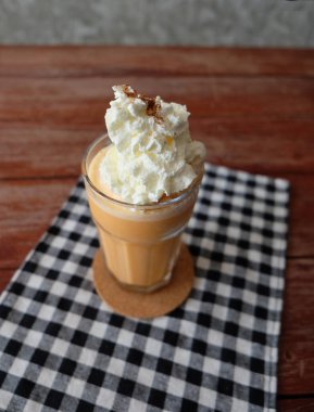 Ahşap masa cam bardakta süt smoothies ile buzlu çay.