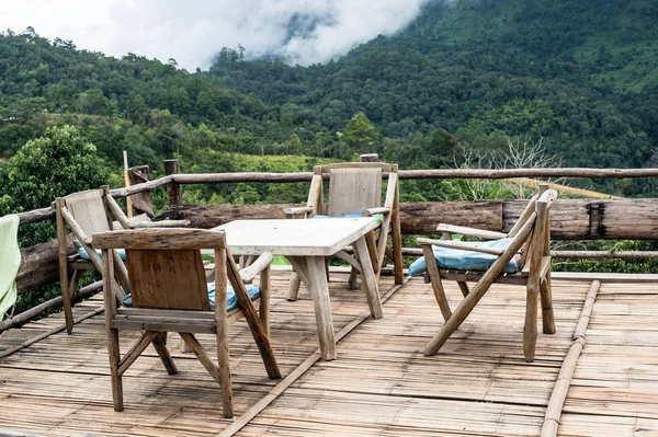 chairs in a wooden terrace natural hill background