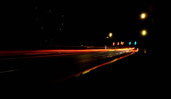 Iluminación borrosa y luces nocturnas, desenfoque del movimiento del tráfico del coche —  Fotos de Stock