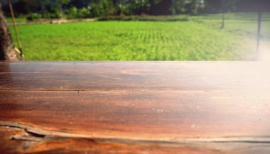 Sabah bahçesindeki bulanık yeşilin üzerindeki boş ahşap masa. Ürünlerinizi görüntülemek veya montajlamak için kullanılabilir