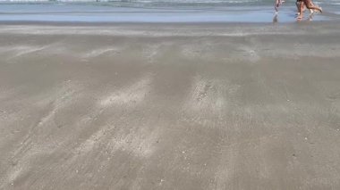 Aile, sahilde koşan çocuklar.