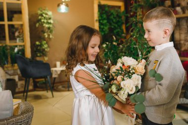 Anne ve kızı caffe çiçeklerle. Evlat annesine çiçek ver. sevimli bir aile. Dünya Kadınlar günü 8 Mart kutluyor