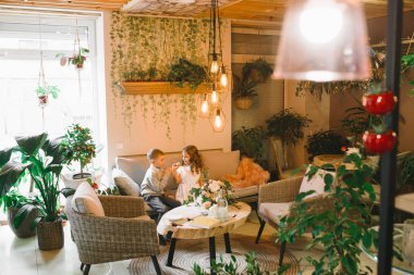 Anne ve kızı caffe çiçeklerle. Evlat annesine çiçek ver. sevimli bir aile. Dünya Kadınlar günü 8 Mart kutluyor