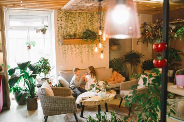 Anne ve kızı caffe çiçeklerle. Evlat annesine çiçek ver. sevimli bir aile. Dünya Kadınlar günü 8 Mart kutluyor