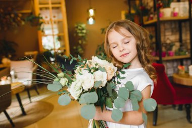 Anne ve kızı caffe çiçeklerle. Evlat annesine çiçek ver. sevimli bir aile. Dünya Kadınlar günü 8 Mart kutluyor