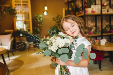 Anne ve kızı caffe çiçeklerle. Evlat annesine çiçek ver. sevimli bir aile. Dünya Kadınlar günü 8 Mart kutluyor