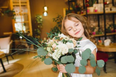 Anne ve kızı caffe çiçeklerle. Evlat annesine çiçek ver. sevimli bir aile. Dünya Kadınlar günü 8 Mart kutluyor