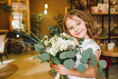 Anne ve kızı caffe çiçeklerle. Evlat annesine çiçek ver. sevimli bir aile. Dünya Kadınlar günü 8 Mart kutluyor