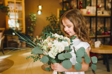 Anne ve kızı caffe çiçeklerle. Evlat annesine çiçek ver. sevimli bir aile. Dünya Kadınlar günü 8 Mart kutluyor