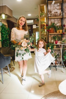 Anne ve kızı caffe çiçeklerle. Evlat annesine çiçek ver. sevimli bir aile. Dünya Kadınlar günü 8 Mart kutluyor