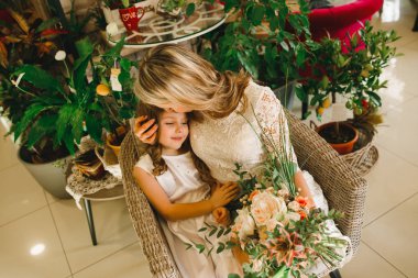 Anne ve kızı caffe çiçeklerle. Evlat annesine çiçek ver. sevimli bir aile. Dünya Kadınlar günü 8 Mart kutluyor