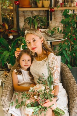 Anne ve kızı caffe çiçeklerle. Evlat annesine çiçek ver. sevimli bir aile. Dünya Kadınlar günü 8 Mart kutluyor