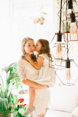 Anne ve kızı caffe çiçeklerle. Evlat annesine çiçek ver. sevimli bir aile. Dünya Kadınlar günü 8 Mart kutluyor