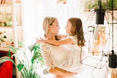 Anne ve kızı caffe çiçeklerle. Evlat annesine çiçek ver. sevimli bir aile. Dünya Kadınlar günü 8 Mart kutluyor