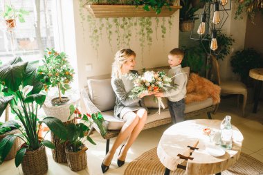 Anne ve kızı caffe çiçeklerle. Evlat annesine çiçek ver. sevimli bir aile. Dünya Kadınlar günü 8 Mart kutluyor