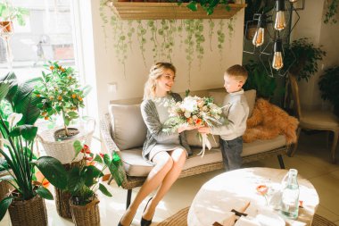 Anne ve kızı caffe çiçeklerle. Evlat annesine çiçek ver. sevimli bir aile. Dünya Kadınlar günü 8 Mart kutluyor