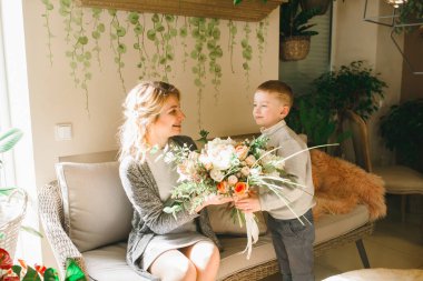 Anne ve kızı caffe çiçeklerle. Evlat annesine çiçek ver. sevimli bir aile. Dünya Kadınlar günü 8 Mart kutluyor