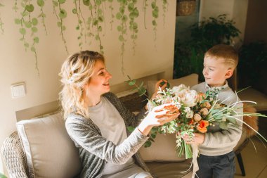 Anne ve kızı caffe çiçeklerle. Evlat annesine çiçek ver. sevimli bir aile. Dünya Kadınlar günü 8 Mart kutluyor