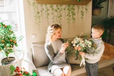 Anne ve kızı caffe çiçeklerle. Evlat annesine çiçek ver. sevimli bir aile. Dünya Kadınlar günü 8 Mart kutluyor