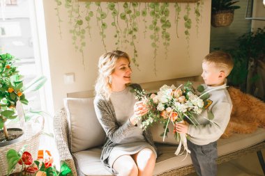 Anne ve kızı caffe çiçeklerle. Evlat annesine çiçek ver. sevimli bir aile. Dünya Kadınlar günü 8 Mart kutluyor