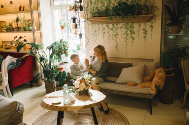 Anne ve kızı caffe çiçeklerle. Evlat annesine çiçek ver. sevimli bir aile. Dünya Kadınlar günü 8 Mart kutluyor