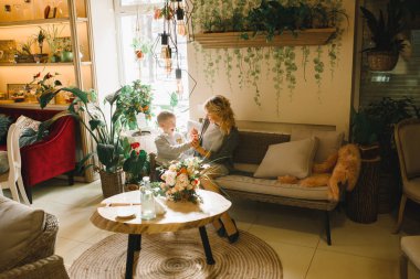 Anne ve kızı caffe çiçeklerle. Evlat annesine çiçek ver. sevimli bir aile. Dünya Kadınlar günü 8 Mart kutluyor