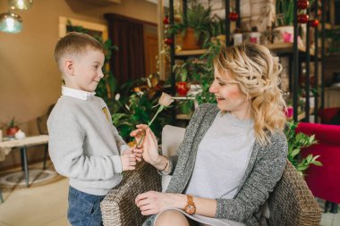 Anne ve kızı caffe çiçeklerle. Evlat annesine çiçek ver. sevimli bir aile. Dünya Kadınlar günü 8 Mart kutluyor