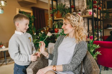 Anne ve kızı caffe çiçeklerle. Evlat annesine çiçek ver. sevimli bir aile. Dünya Kadınlar günü 8 Mart kutluyor