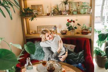 Anne ve kızı caffe çiçeklerle. Evlat annesine çiçek ver. sevimli bir aile. Dünya Kadınlar günü 8 Mart kutluyor