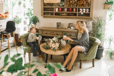 Anne ve kızı caffe çiçeklerle. Evlat annesine çiçek ver. sevimli bir aile. Dünya Kadınlar günü 8 Mart kutluyor