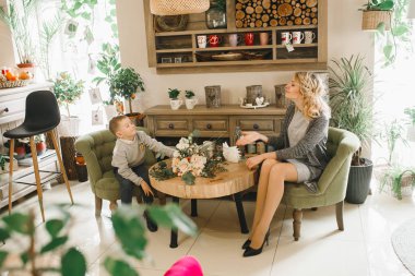 Anne ve kızı caffe çiçeklerle. Evlat annesine çiçek ver. sevimli bir aile. Dünya Kadınlar günü 8 Mart kutluyor